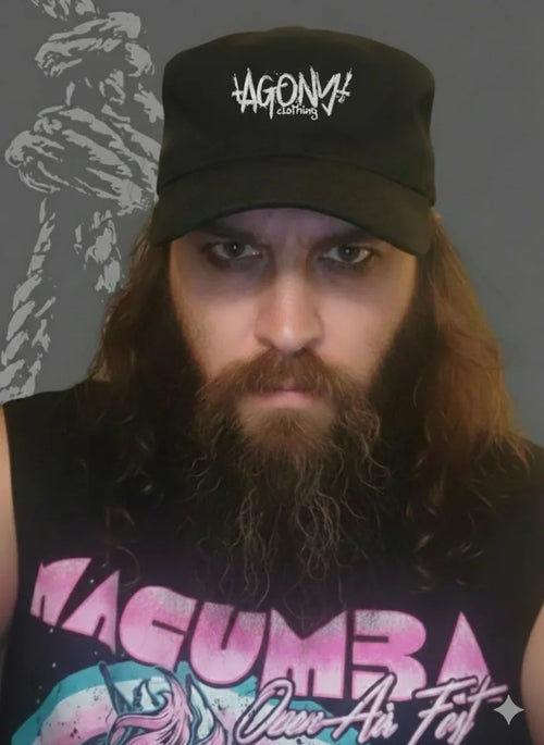 Homme barbu portant une casquette Agony Clothing, style alternatif, fond sombre, streetwear Toulouse